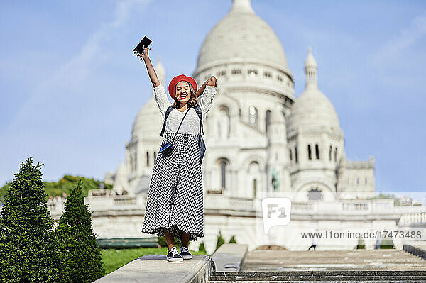 Woman holding mobile phone at Basilique Du Sacre Coeur  Montmartre in Paris  France