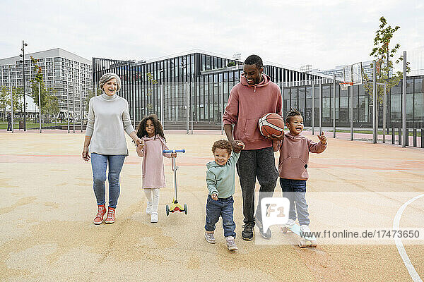 Smiling family walking together on sports field