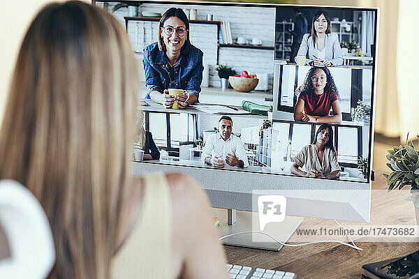 Female freelancer attending video conference at home office