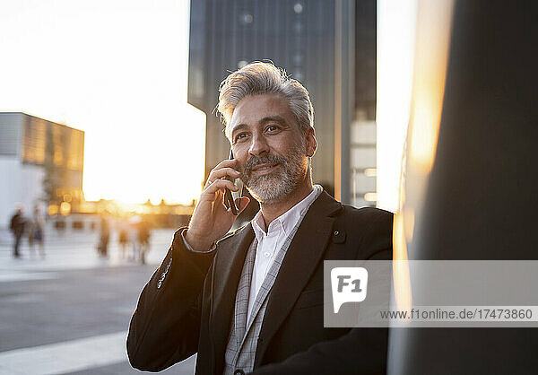 Contemplating businessman talking on smart phone
