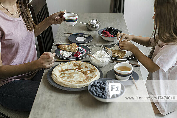 Mother having breakfast with daughter at home
