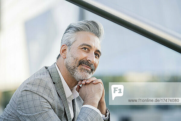 Smiling businessman with hand on chin