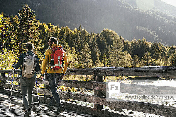 Mature couple with backpacks hiking on sunny day