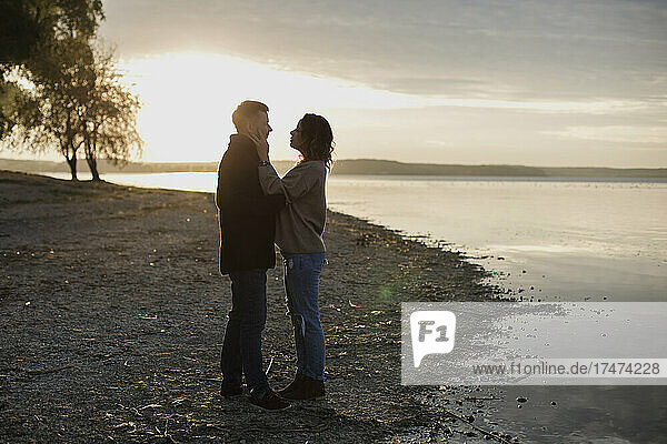 Romantic couple standing at lakeshore