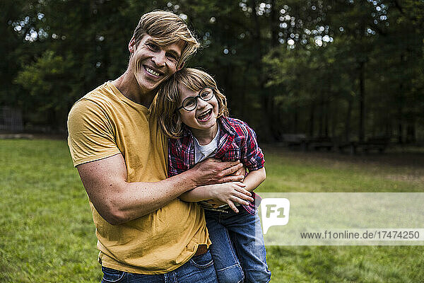 Happy father hugging son in park