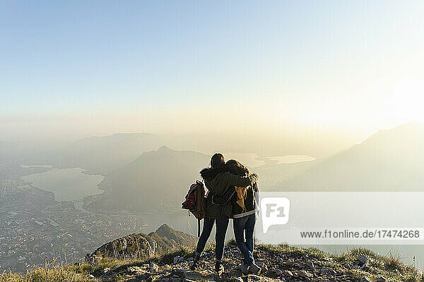 Woman embracing friend on mountain peak at Lecco  Italy
