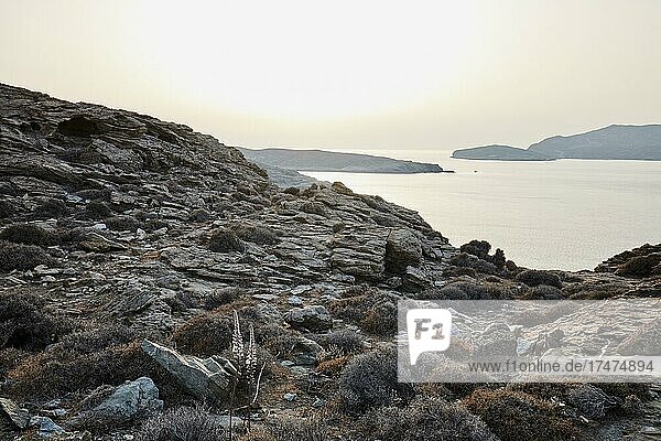 Küste von Tinos an der engsten Stelle zu Andros im ungewöhnlich weißen Sonnenuntergangslicht. Tinos  Kykladen  Griechenland  Europa