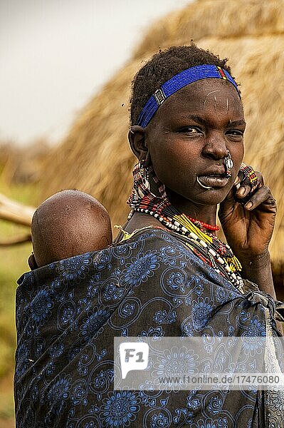 Woman with her child before her hut  Jiye tribe  Eastern Equatoria State  South Sudan  Africa