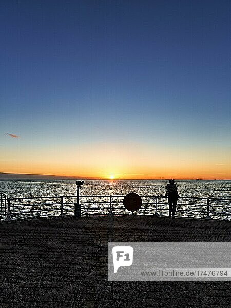Visitors on Seafront Promenade  Silhouette  Looking out to sea  Sunset  Cardigan Bay  Aberystwyth  Ceredigion  Wales  United Kingdom  Europe