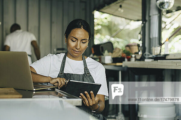 Female owner working on digital tablet in food truck