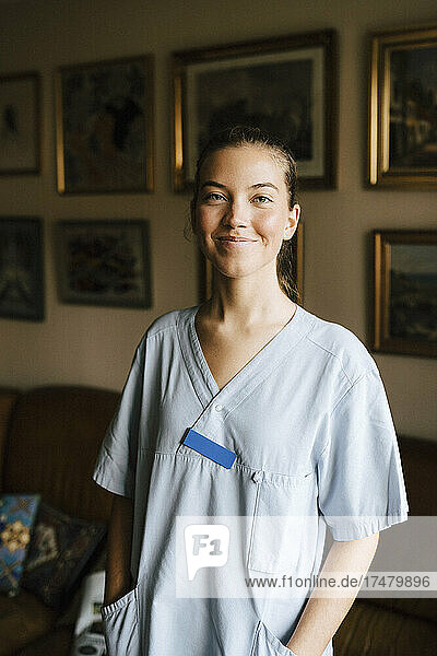 Lächelnde Pflegerin mit Händen in den Taschen im Pflegeheim