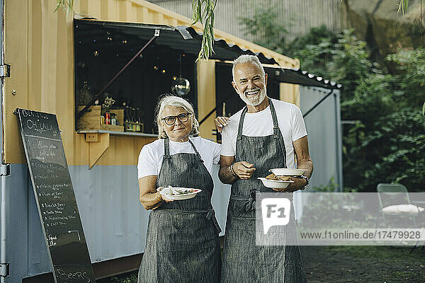 Porträt eines älteren Mannes und einer Frau mit Essen im Park