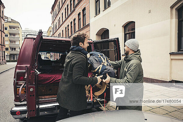 Reife männliche Freunde beladen das Gepäck im Wohnmobil während einer Autoreise