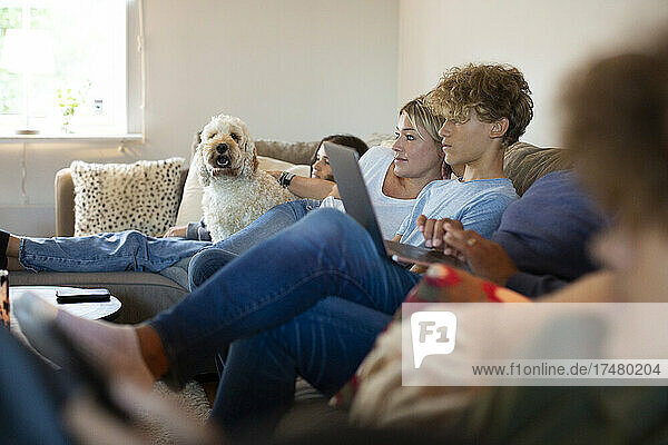 Family sitting together on sofa in living room at home