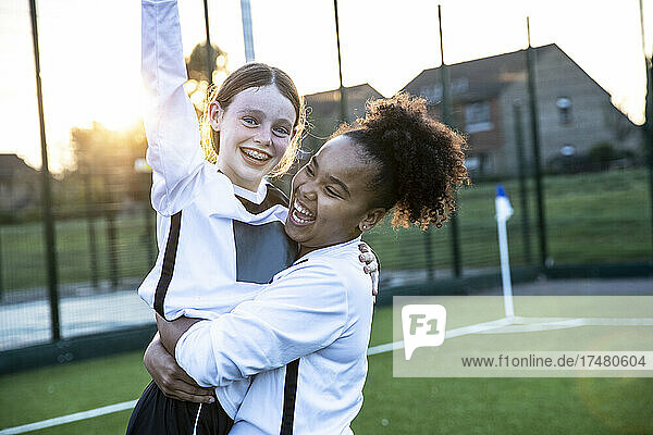 UK  Happy female soccer players (10-11  12-13) embracing in field