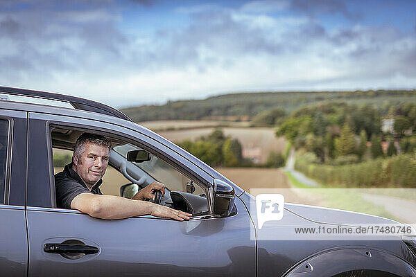 Portrait of farmer sitting in car