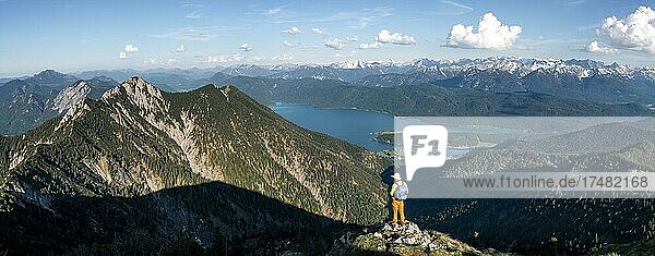 Wanderer blickt auf Bergpanorama Wanderer am Gipfel des Heimgarten Gratwanderung Herzogstand Heimgarten hinten gipfel des Herzogstand und schneebedecktes Karwendel und Walchensee Oberbayern Bayern Deutschland Europa