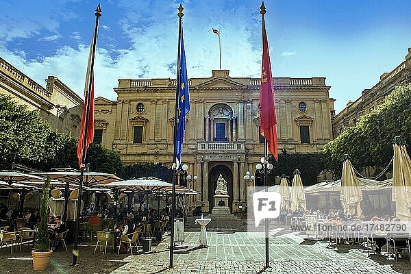 Blick auf Gebäude von Nationalbibliothek von Malta  davor Skulptur aus Marmor von Queen Victoria  im Vordergrund Flaggenmast  seitlich Touristen in Open Air Café  Valletta  Malta  Europa
