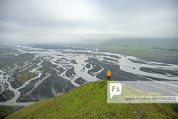 Hiker on a hill  view over alluvial land  river meandering  Dímonarhellir  Suðurland  Iceland  Europe