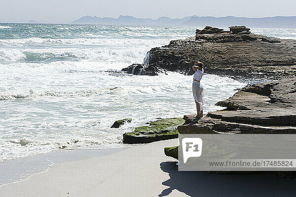 Teenage girl exploring a rocky shore on the Atlantic ocean coastline