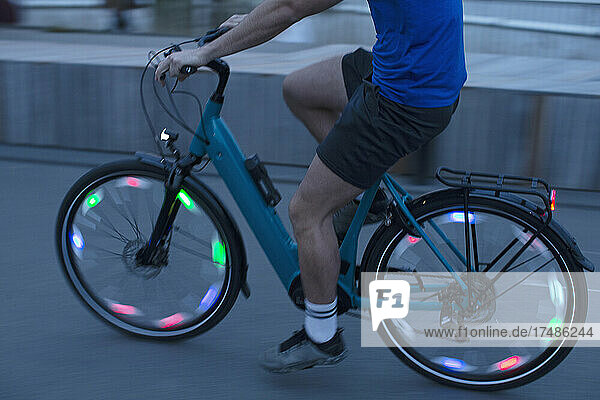 Mann fährt beleuchtetes Fahrrad