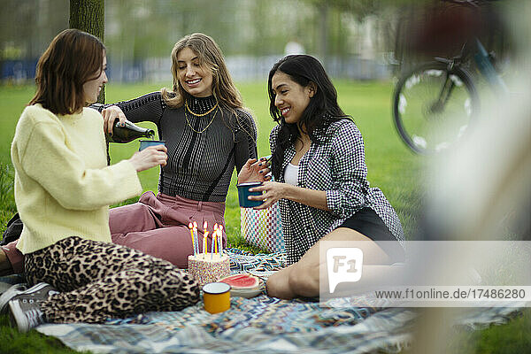Junge Frauen  die im Park Geburtstag feiern