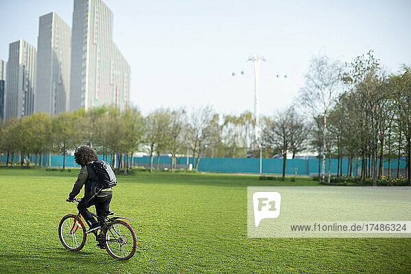 Junger Mann fährt Fahrrad in einem Stadtpark  London  UK