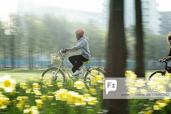 Junge Frau fährt Fahrrad in einem sonnigen Frühlingspark