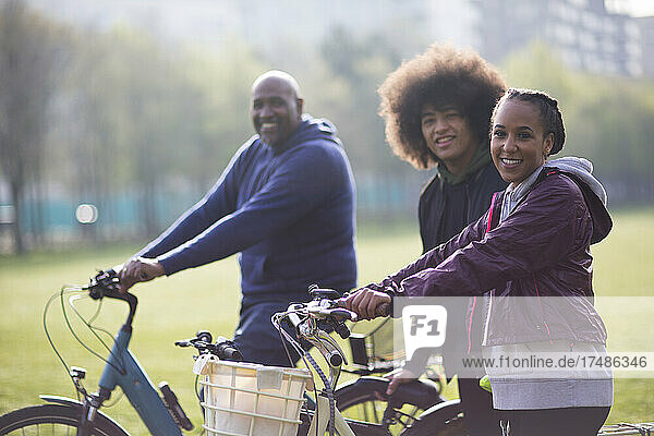 Porträt glücklicher Vater und Teenager-Kinder mit Fahrrädern im Park