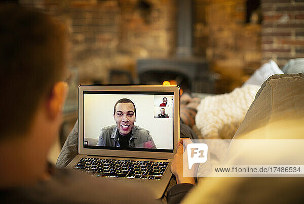Mann hält Videokonferenz mit Kollegen auf dem Laptop-Bildschirm