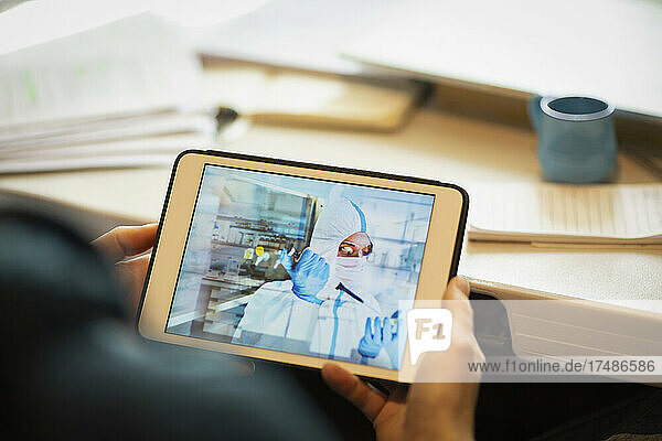 Mann beobachtet Wissenschaftler mit Pipette auf digitalem Tablet-Bildschirm