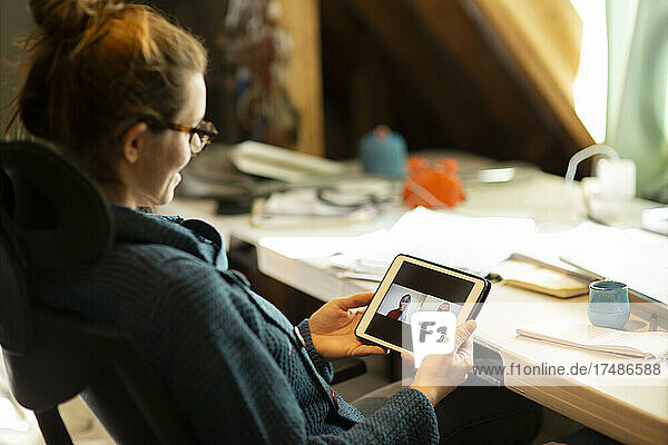 Frau bei Videokonferenz mit Kollegen auf digitalem Tablet-Bildschirm