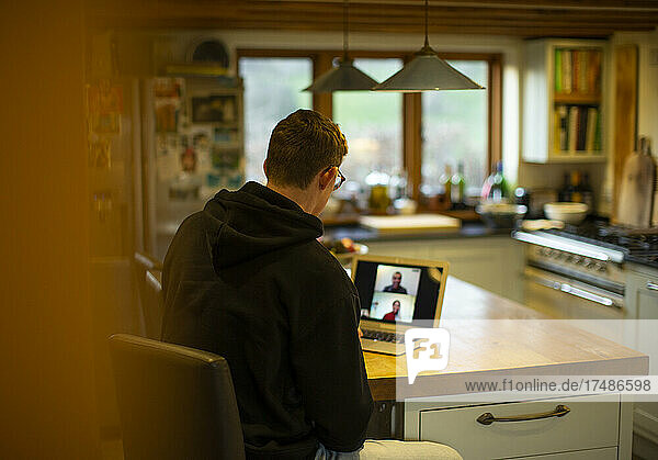 Mann bei der Arbeit zu Hause Videochat mit Kollegen am Laptop in der Küche