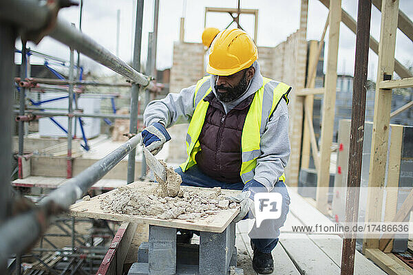 Männlicher Bauarbeiter beim Mischen von Beton auf der Baustelle