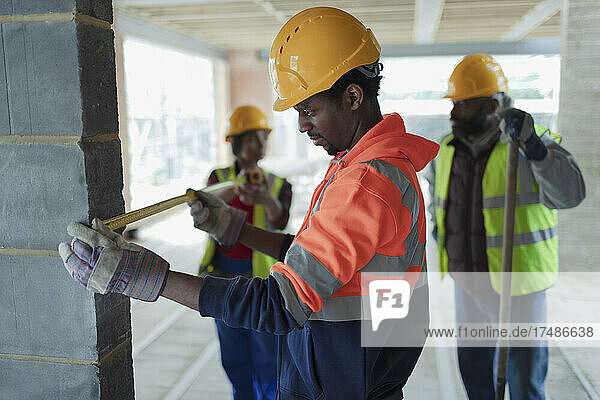 Bauarbeiter mit Maßband auf einer Baustelle