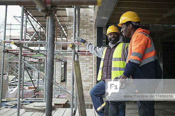 Männliche Bauarbeiter unterhalten sich auf der Baustelle