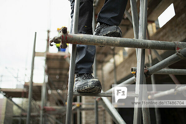 Bauarbeiter klettert auf ein Gerüst auf einer Baustelle
