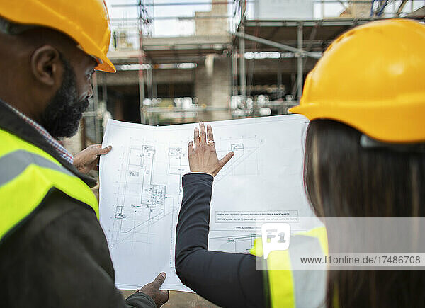 Architects with blueprints at construction site