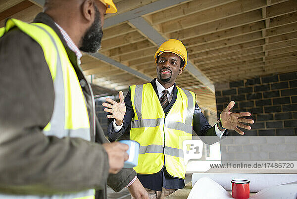 Male engineer and foreman talking at construction site