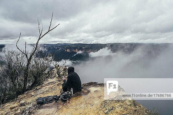 Männlicher Wanderer rastet auf einer abgelegenen Bergkuppe  Australien