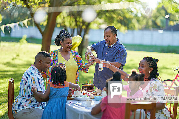 Mehrgenerationenfamilie feiert Geburtstag im sommerlichen Hinterhof