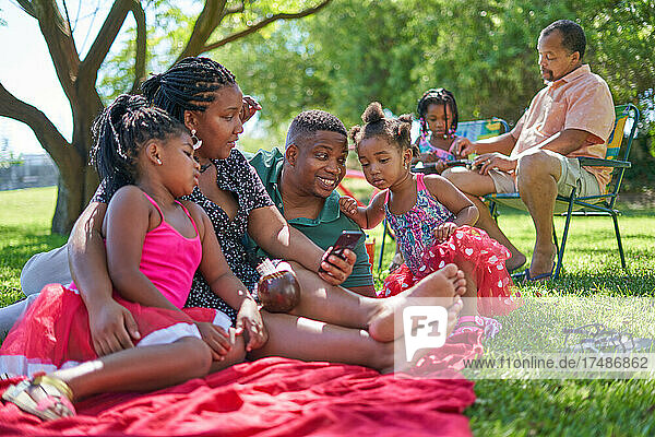 Familie entspannt sich auf einer Decke im Sommerpark