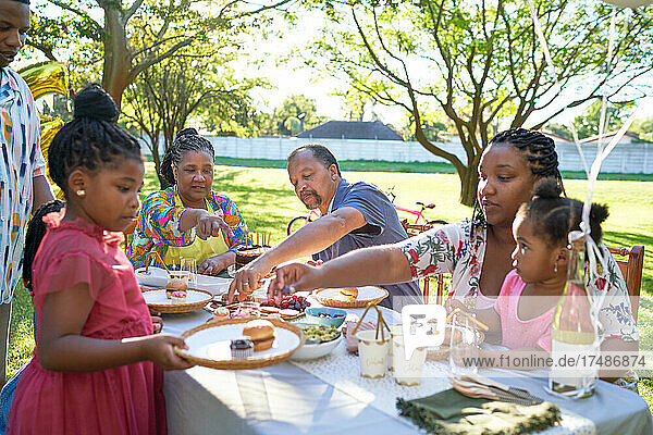 Mehrgenerationenfamilie feiert Geburtstag am sommerlichen Terrassentisch