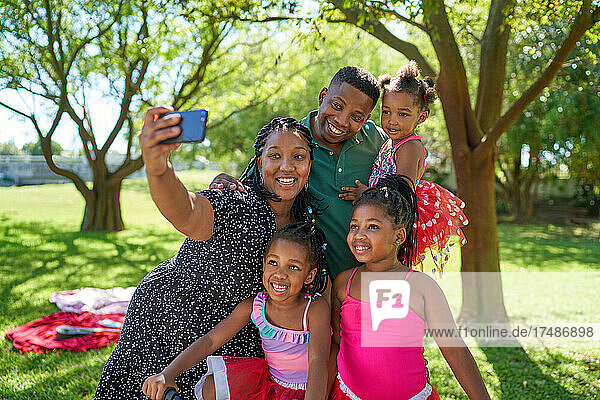 Glückliche Familie nimmt Selfie im Sommer Park