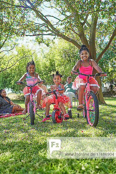 Porträt niedlichen Schwestern fahren Fahrräder und Dreirad im Sommer Park