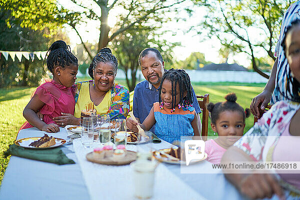 Glückliche Mehrgenerationenfamilie feiert Geburtstag am Terrassentisch