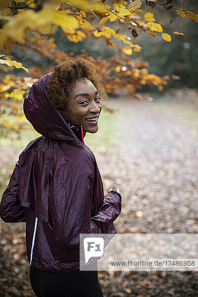 Porträt glückliche junge Frau joggt im Herbst Park