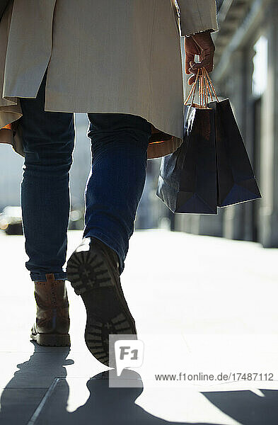 Nahaufnahme Mann mit Einkaufstaschen auf sonnigem Gehweg
