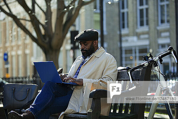 Geschäftsmann arbeitet am Laptop im Stadtpark