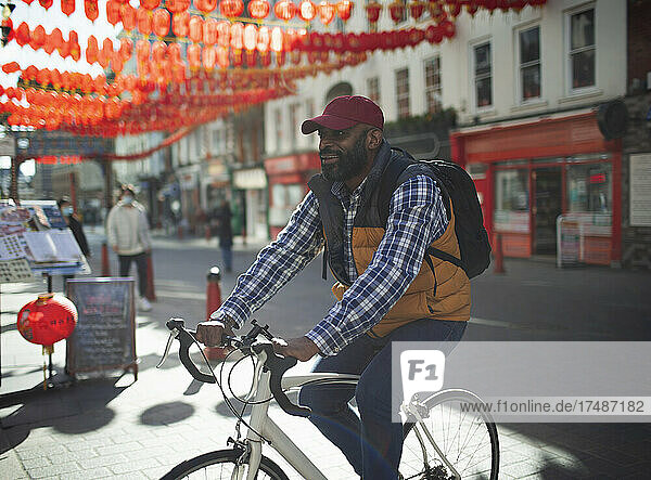 Mann fährt Fahrrad auf einer sonnigen Straße  Chinatown  London  UK